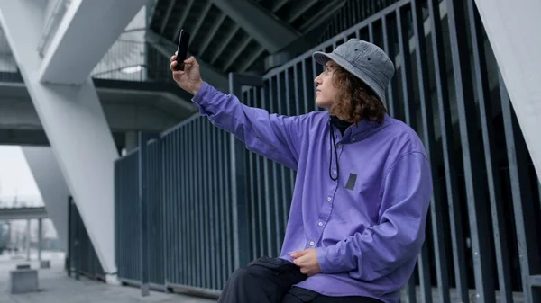 Elegante hipster tomando selfie en el teléfono inteligente. Hombre enfocado posando en la cámara del teléfono. — Foto de Stock