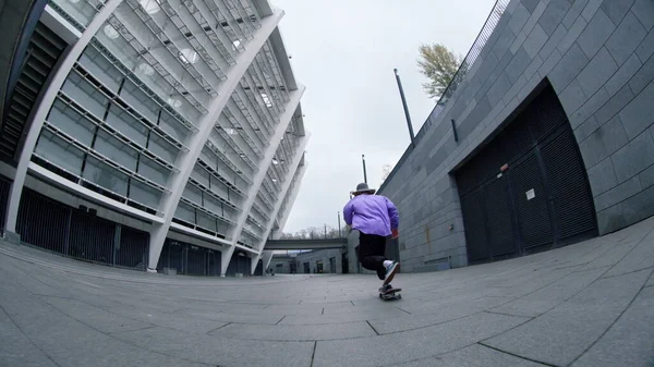 Joven skater haciendo truco en la calle de la ciudad. Tipo activo cayendo durante la lección. — Foto de Stock