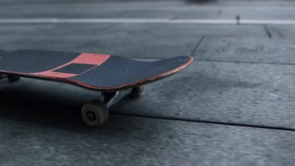 Patineta de primer plano rodando en la calle de la ciudad. Longboard negro y rojo al aire libre. — Vídeos de Stock