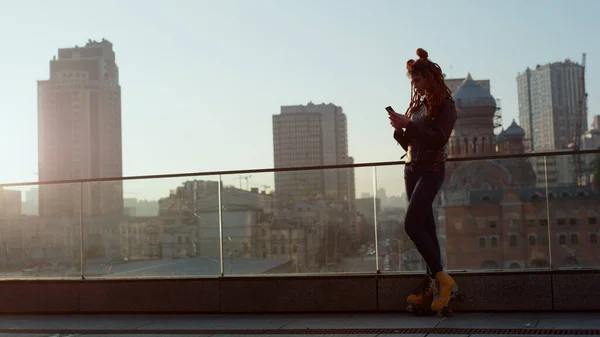 Mujer con estilo usando el teléfono exterior. Hermosa chica mirando al teléfono celular al aire libre. —  Fotos de Stock