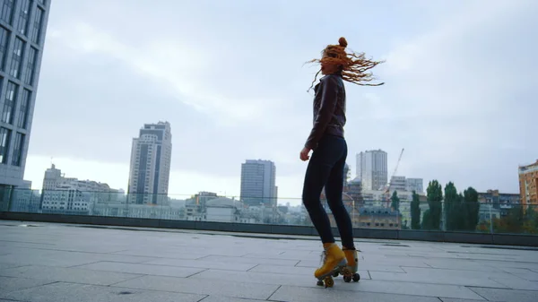 Chica de jengibre enfocada montando patines. Patinador rodillo girando en la calle —  Fotos de Stock