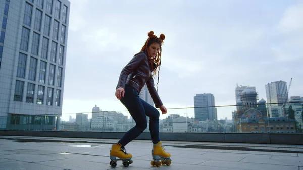 Focused roller skater riding outside. Active woman training on rollerblades.