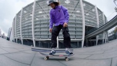 Sportif adam dışarıda takla atıyor. Dışarıda kaykay süren aktif hippi..