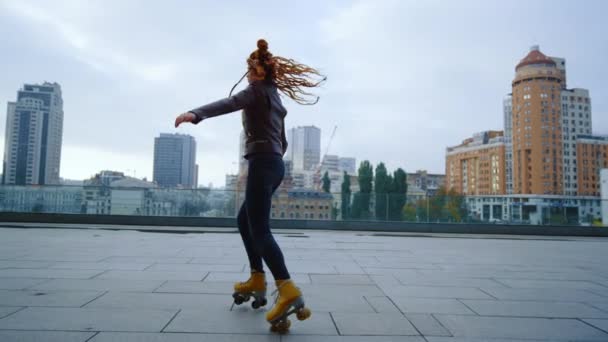 Mulher de gengibre esportivo executando elementos de patins no fundo urbano. — Vídeo de Stock