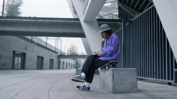 Konzentrierter Mann mit Blick auf die Stadtstraße. Stylischer Hipster mit Handy im Freien. — Stockvideo