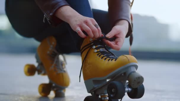 Onbekende rolschaatser bereidt zich voor om te trainen. Vrouw handen strikken veters op schaatsen. — Stockvideo