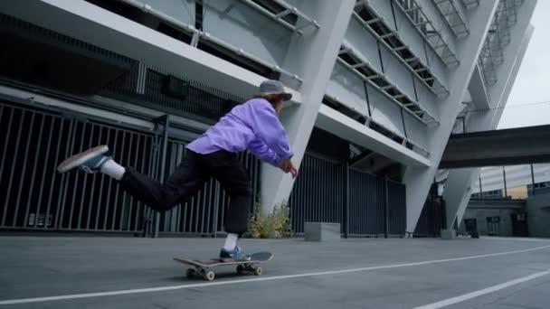 Joven patinador practicando en el estadio de la ciudad. Deportivo hipster cabalgando a bordo. — Vídeo de stock