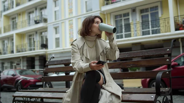 Älskade par träffas utomhus. Kvinnan dricker kaffe. Man sluter flickväns ögon. — Stockfoto