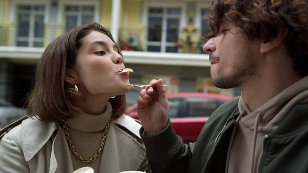 Casal afetuoso alimentando uns aos outros ao ar livre. Mulher sedutora homem na rua. — Fotografia de Stock