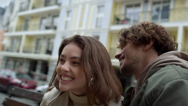 Casal alegre rindo na rua da cidade. Homem sussurrando história engraçada para mulher. — Fotografia de Stock