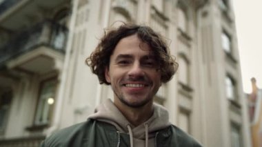 Şehir caddesinde gülümseyen neşeli bir adam. Neşeli hipster Eski kasabada mutlu hissediyordu.