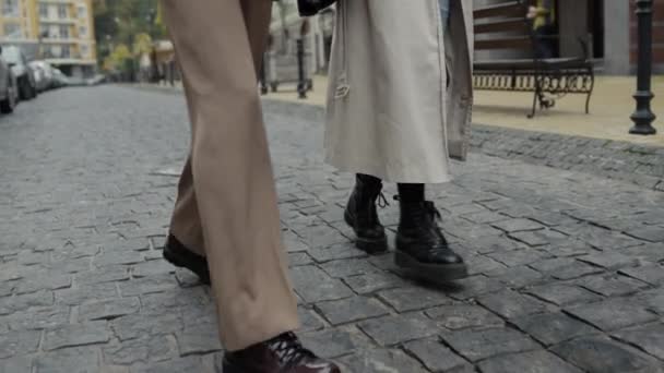 Şehir caddesinde zıplayan iki bacak. Bilinmeyen adam ve kadın dışarıda yürüyor.. — Stok video