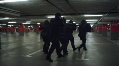 SWAT ekipleri otoparkı araştırıyor. Özel harekat polisi tüfekle ateş ediyor.
