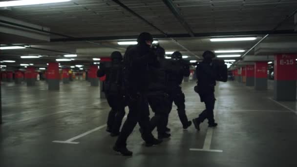 SWAT-troepen verkennen de parkeerplaats. Special ops politieteam schieten met geweren — Stockvideo