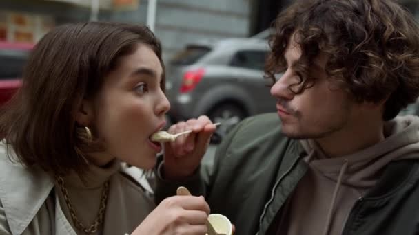 Joli couple dégustant de la glace dans la rue. Paire date de dépense en plein air. — Video