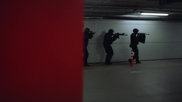 Oficiales de policía SWAT caminando en el estacionamiento. Fuerzas especiales apuntando rifles de asalto — Vídeos de Stock