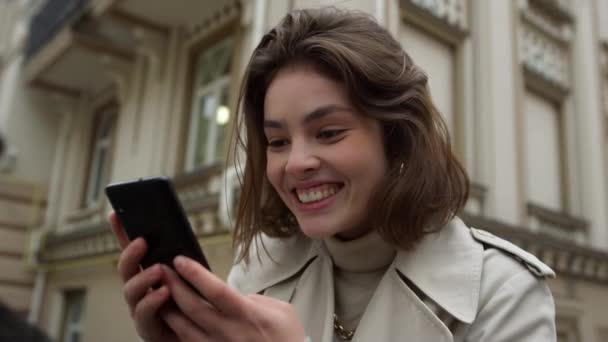 Nadšená žena má ve městě videohovor. Šťastná dívka pomocí telefonu kamery venku. — Stock video