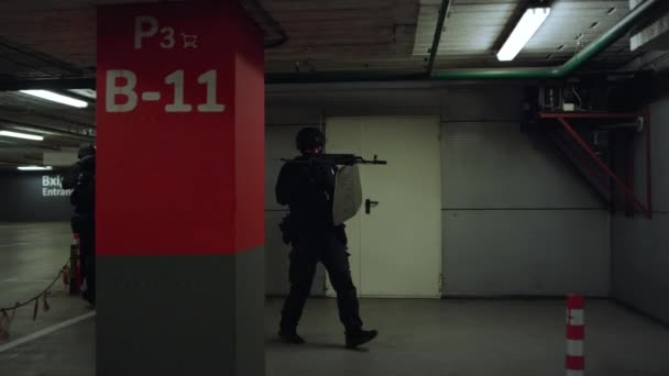 Police spéciale enquêtant sur le bâtiment. Des policiers marchent sur le parking — Video