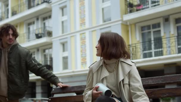 Glückliches Paar beim Date auf der Bank im Freien. Mann umarmt Frau auf Stadtstraße. — Stockvideo