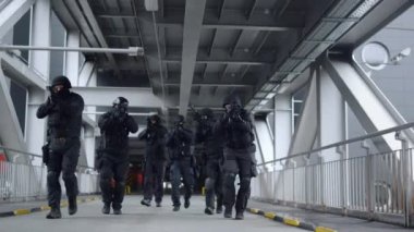 Tüfekli SWAT timi köprüde ilerliyor. Polis özel kuvvetleri etrafa bakıyor.