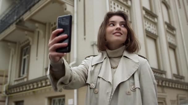 Una donna sorridente che si fa un selfie per strada. Ragazza labbra bronzanti per fotocamera del telefono. — Video Stock