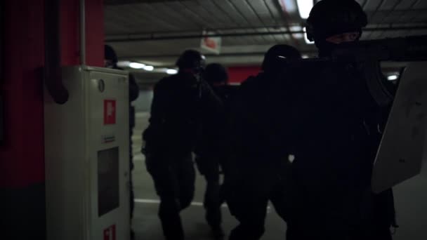 Группа бойцов спецназа, идущих по подземному паркингу с оружием — стоковое видео