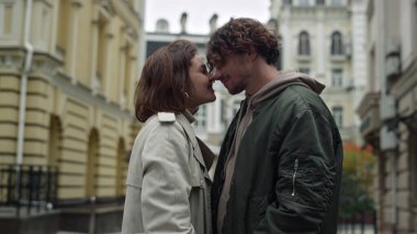 Aşk çifti şehir sokağında burunlarını sürtüyor. Erkek ve kadın dışarıda flört ediyorlar..
