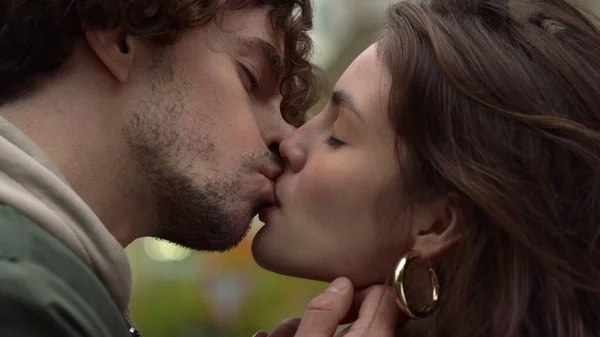 快乐的恋人在城市街道上亲吻。女人在户外咬男朋友的唇. — 图库照片