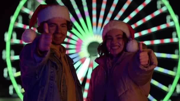 一对快乐的夫妇在户外竖起大拇指.欢欢喜喜的一对庆祝圣诞节. — 图库视频影像