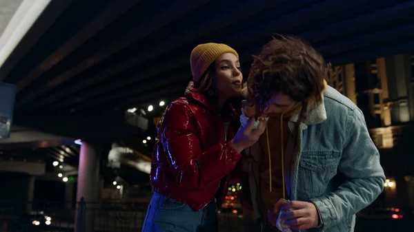 거리에서 키스하는 행복 한 커플. 남자가 여자 햄버거를 밖에서 물다. — 스톡 사진