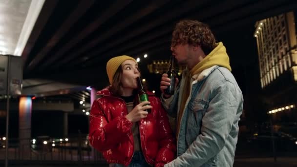 Pareja romántica disfrutando del tiempo juntos bajo el puente. Pareja soplando en botellas. — Vídeos de Stock