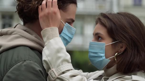 Love couple hugging on urban street. Woman in medical mask touching man hair. — Stock Video