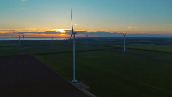 Modern windmills producing renewable alternative energy in rural landscape.