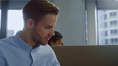 Açık alanda dizüstü bilgisayarda çalışan bir iş adamı. Telefonla cevap veren işçiler 