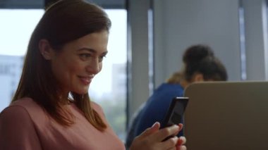 İş kadını akıllı telefondan internete bakıyor. Çalışan cep telefonu kullanıyor