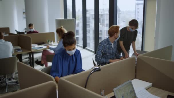 Empleados con máscaras protectoras que trabajan en espacios abiertos. Equipo ocupado en el lugar de trabajo — Vídeos de Stock