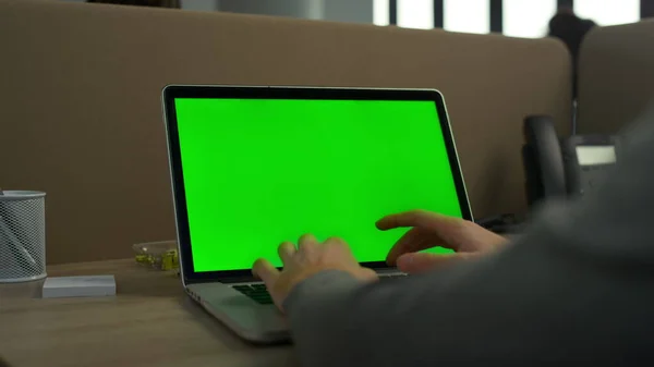 Business man typing laptop computer green screen in office. Man using laptop
