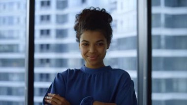 Ofiste poz veren iş kadını. Pencerede duran gülümseyen bayan girişimci