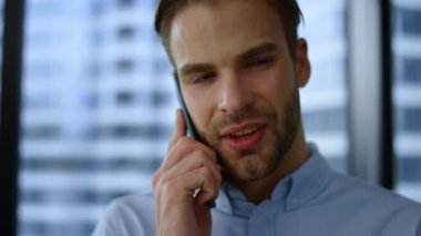 Gülümseyen işadamı akıllı telefondan konuşuyor. Erkek yöneticinin telefon görüşmesi var.