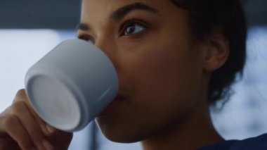 Afrikalı kadın ofiste kahve fincanı içiyor. Profesyonel eğlence kahvesi.