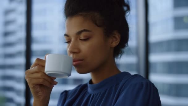 Modern ofiste kahve içen bir iş kadını. Pencereden bakan kadın yönetici — Stok video