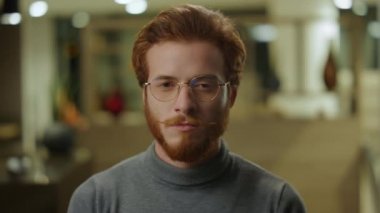 Lobide duran kendine güvenen bir iş adamı. İçerideki kameraya bakan programcı