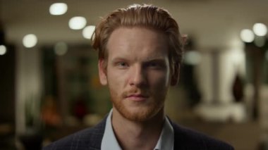 Ofis lobisinde duran bir iş adamı. Gülümseyen erkek işçi kameraya poz veriyor.