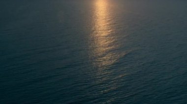 Büyüleyici güneş ışığı yansımalarıyla drone deniz manzarası. Akşamları sakin deniz yüzeyi.