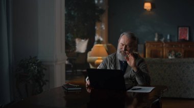 Üst düzey bir işadamı, dizüstü bilgisayarının işini klasik dolabında bitiriyor.