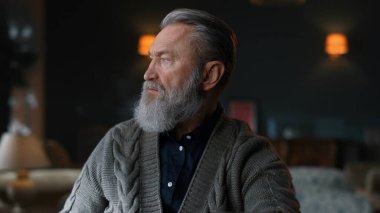 Lüks ev içinde bilgisayarda çalışmaya başlayan düşünceli bir kıdemli adam..