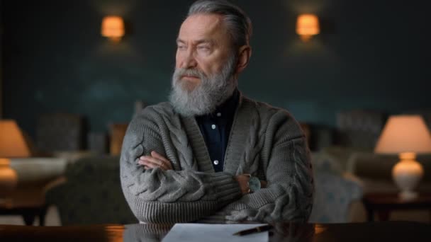 Portrait d'homme âgé assis à table avec les mains croisées dans une armoire vintage. — Video