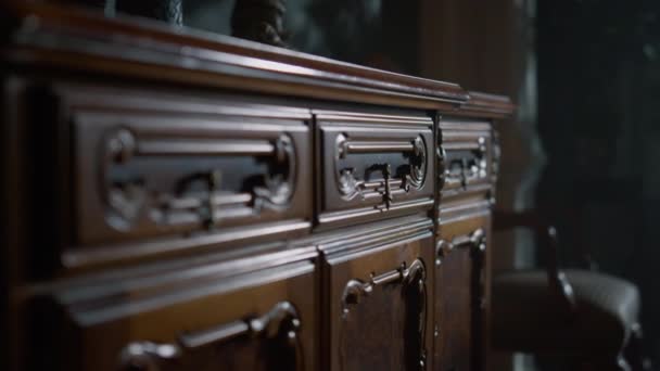 Closeup carved chest of drawers in dark interior. Antique wood dresser indoors. — Stock Video
