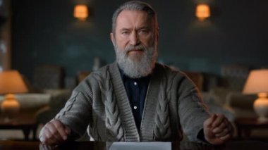 İçerde kontrat imzalayan beyaz saçlı beyefendi portresi. Belge okuyan adam.