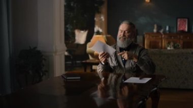 Yaşlı adam antik dolapta bıçakla zarf açıyor. Yaşlı adam.